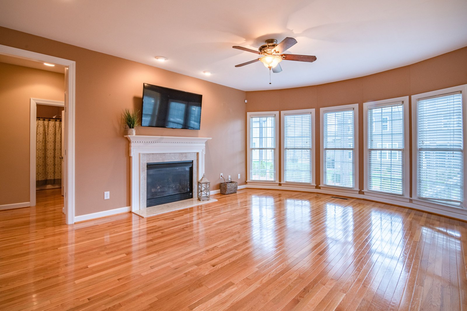 Finished hardwood floor in a bright living room with fireplace